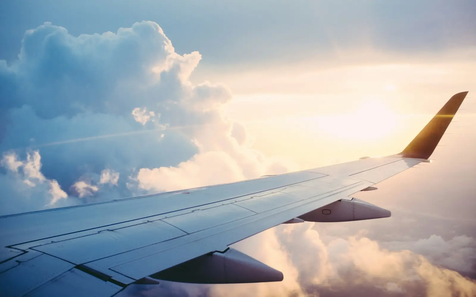 Aile d'avion au-dessus des nuages au coucher du soleil — départ pour étudier en Russie